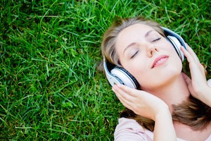Peaceful woman listening to music with headphones outdoors