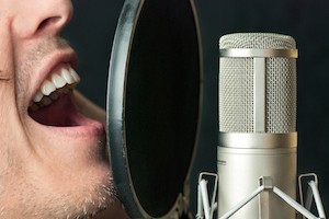 Super close-up of a man singing into a condenser microphone